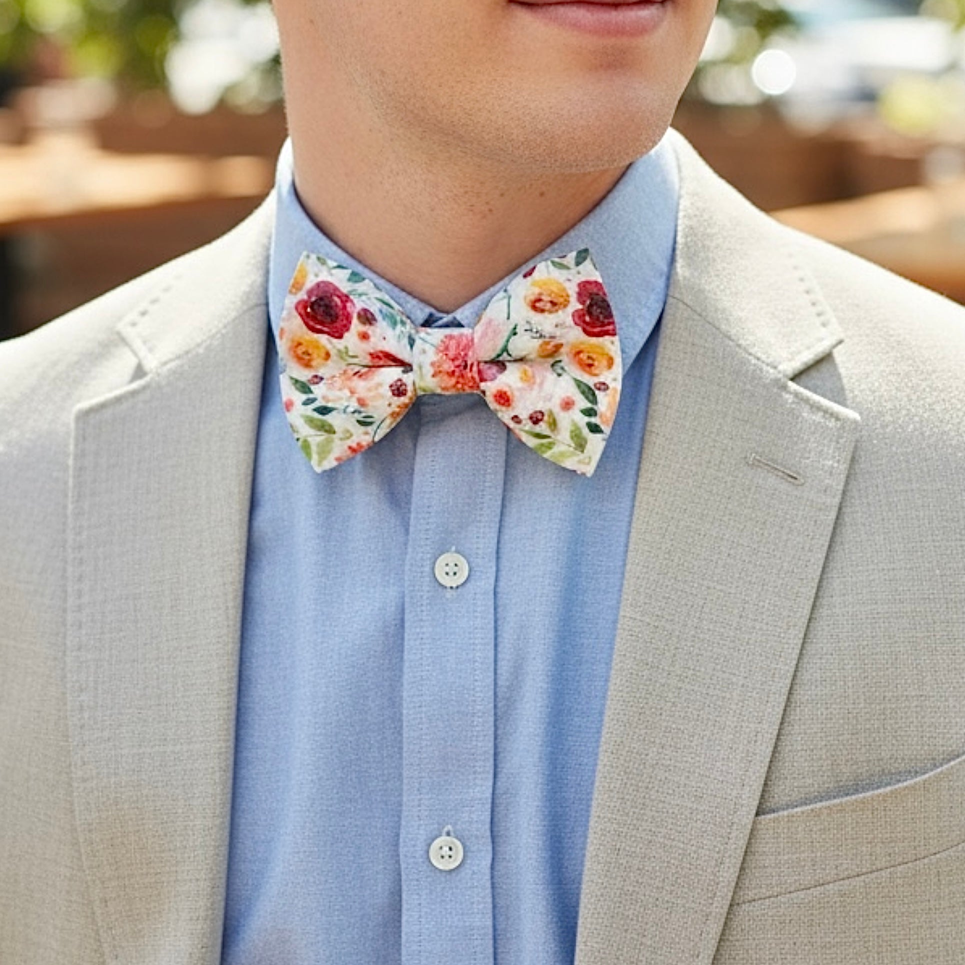 Groomsman in a wildflower floral bow tie getting ready for a wedding.