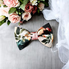 Ivory terracotta floral Bow Tie in for weddings, groomsmen and ring bearers surrounded outfits surrounded by wedding accessories.