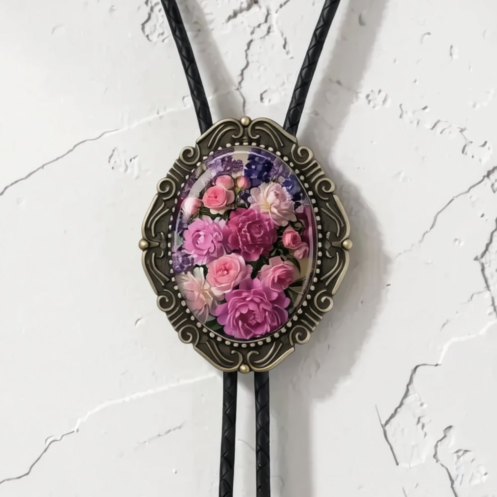 A decorative pendant necklace with a floral design, hanging against a white textured wall.