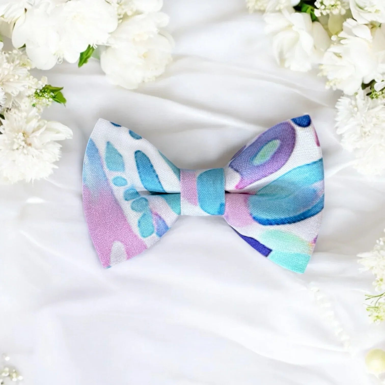Size chart for pre-tied bow ties from The Bold Bow Tie detailing measurements across three sizes. Small is 3.5 inches wide and recommended for ages 6 months to 5 years. Medium is 4 inches wide and recommended for ages 6 to 12 years. Large is 4.5 inches wide and recommended for ages 13 years and up. Visual icons illustrate the relative sizes with horizontal arrows showing that width is measured from wingtip to wingtip. Bottom text notes that all bow ties are pre-tied and ready to add to your outfit.