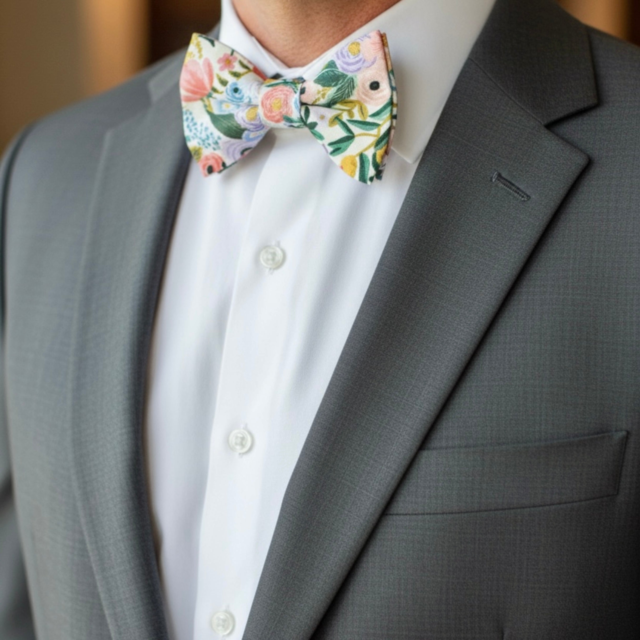 Texture detail of a white cotton floral bow tie featuring high-quality botanical print fabric.