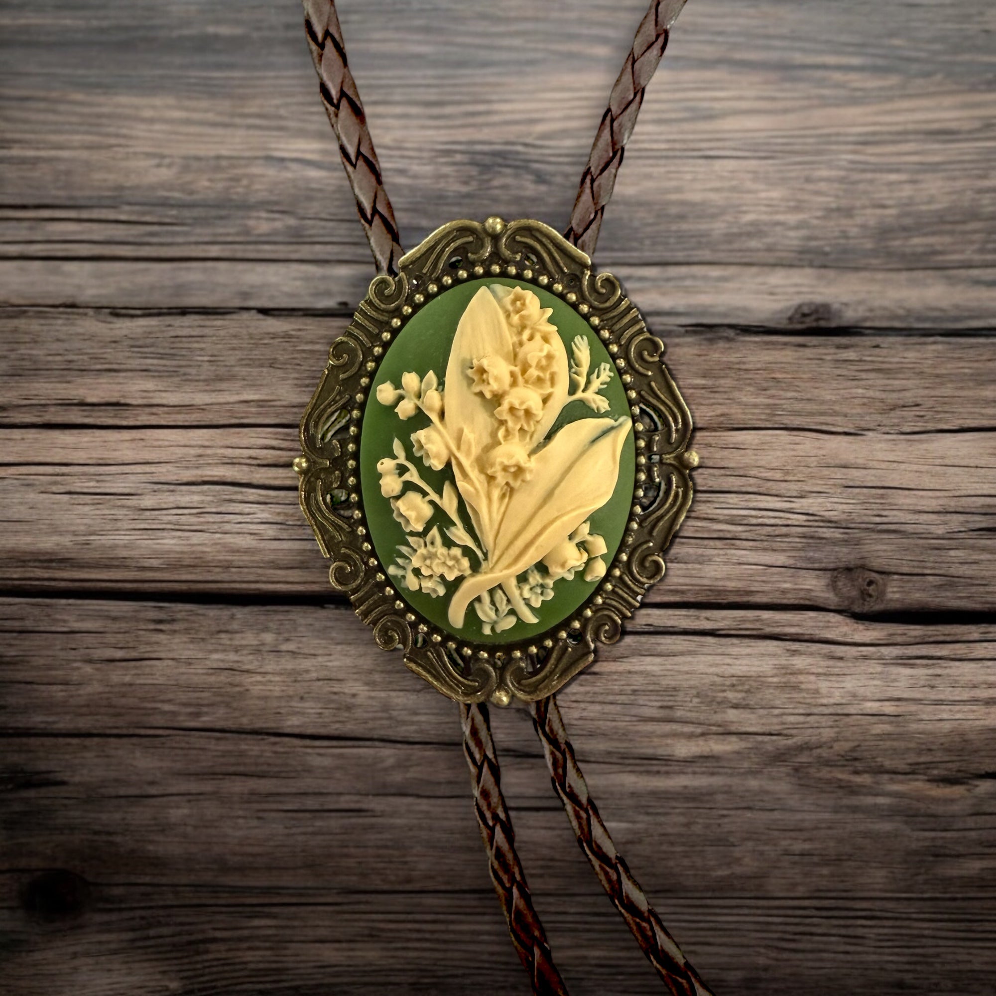 Decorative bolo tie with floral design on a wooden surface