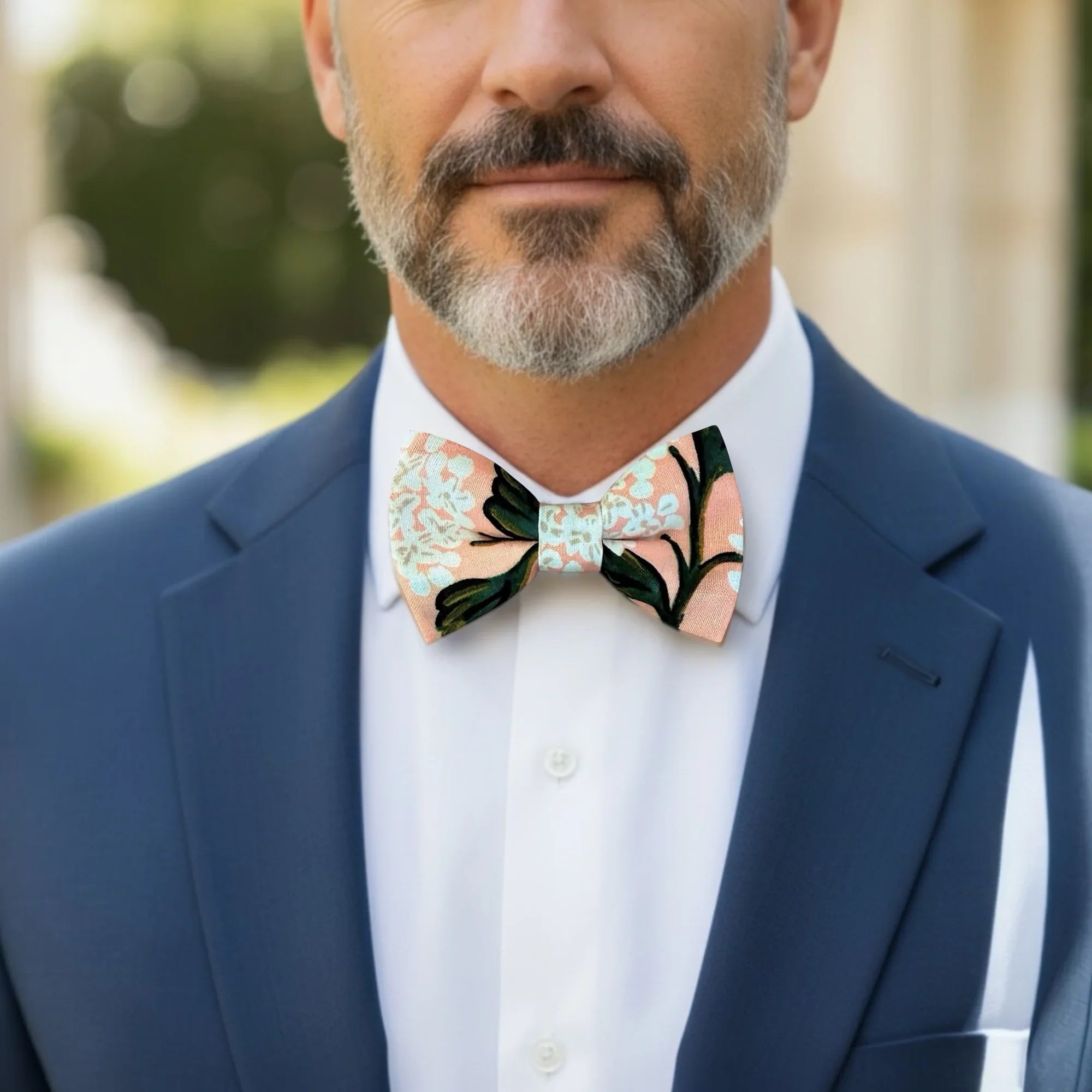 Size chart for pre-tied bow ties from The Bold Bow Tie detailing measurements across three sizes. Small is 3.5 inches wide and recommended for ages 6 months to 5 years. Medium is 4 inches wide and recommended for ages 6 to 12 years. Large is 4.5 inches wide and recommended for ages 13 years and up. Visual icons illustrate the relative sizes with horizontal arrows showing that width is measured from wingtip to wingtip. Bottom text notes that all bow ties are pre-tied and ready to add to your outfit.
