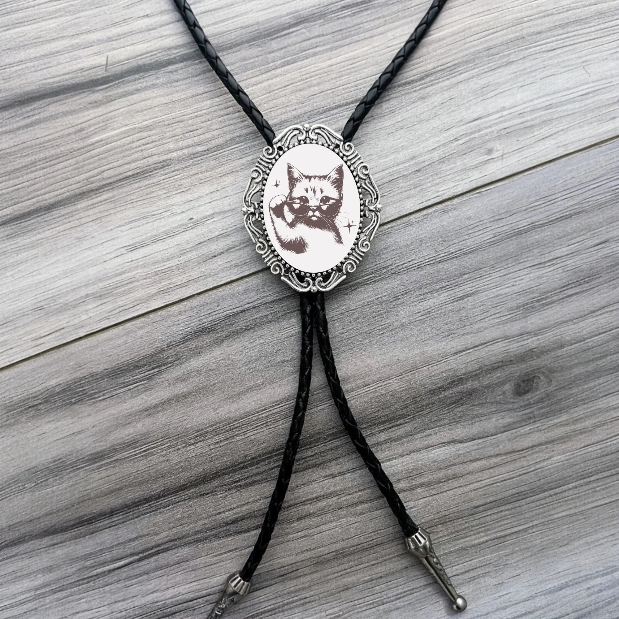 Silver back of a bolo tie with a clamp on a black leather cord