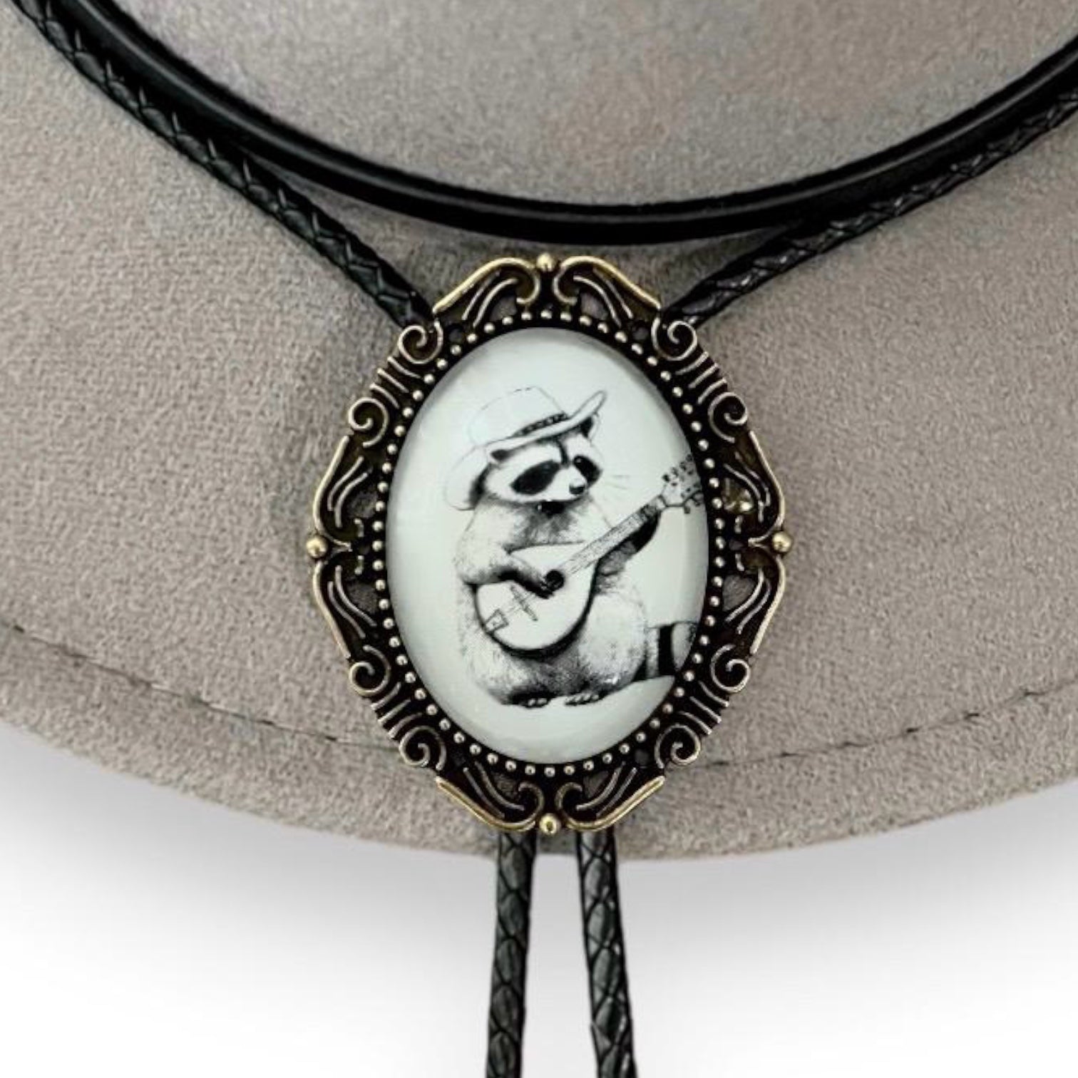 Raccoon bolo tie in black white and bronze.