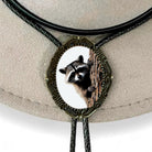 Western Bolo Tie with Raccoon with black leather cord on a wooden table.