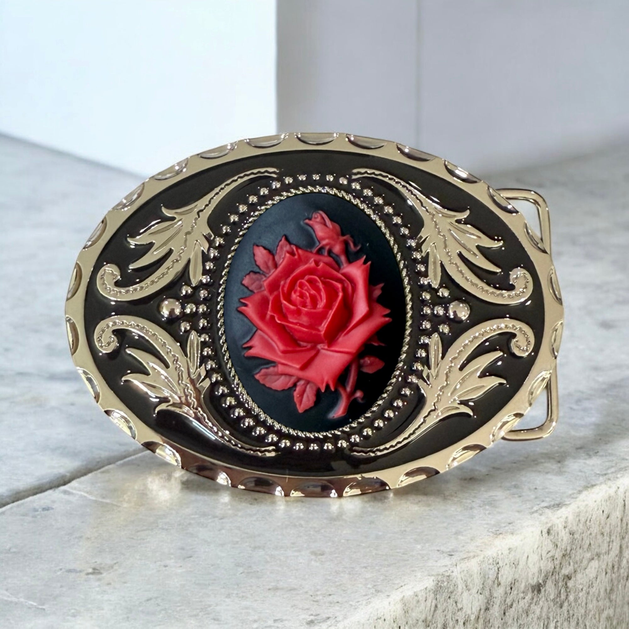 Belt Buckle with Black & Red Rose on a cement table