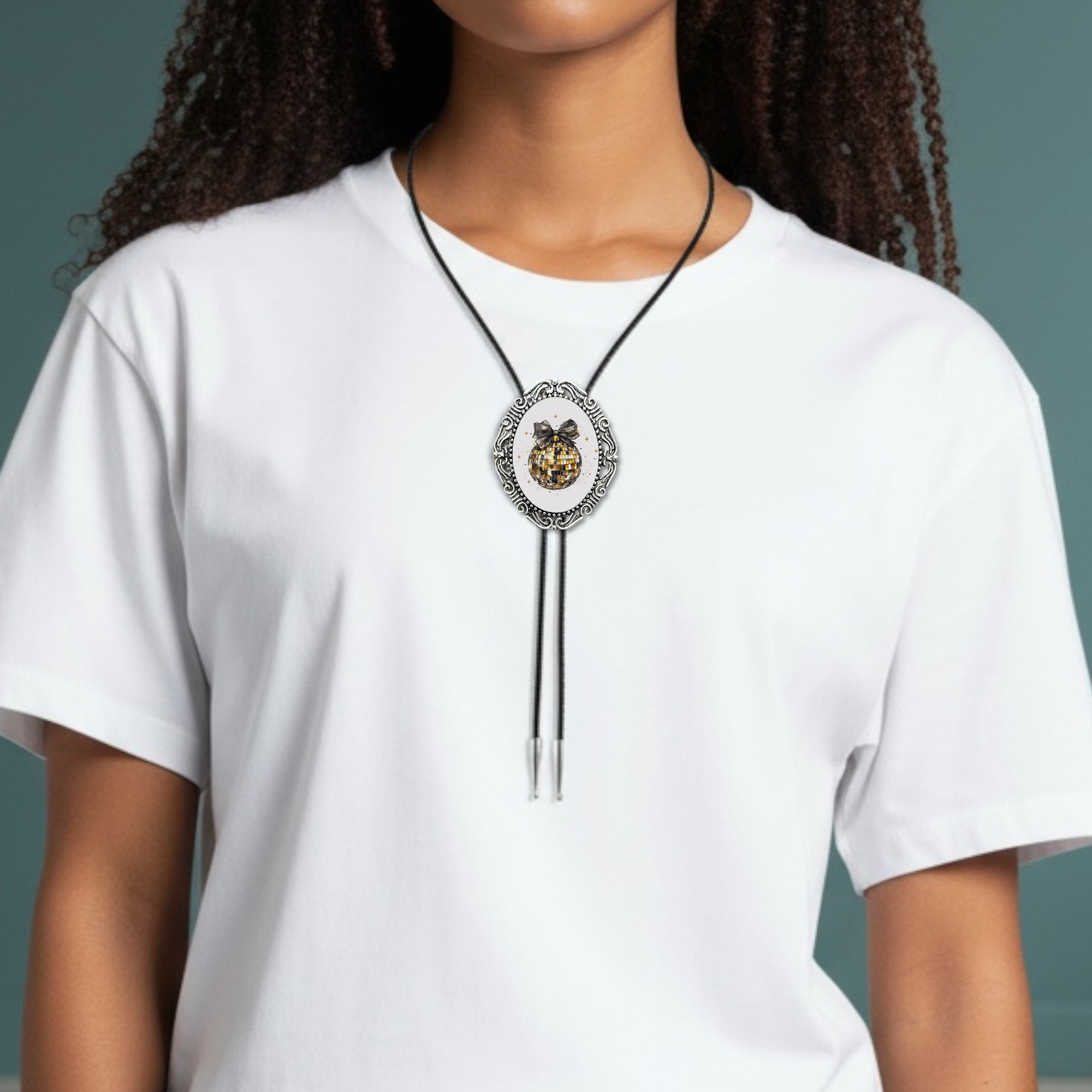 Person wearing a white shirt with a New Year’s Eve bolo tie necklace against a gray background