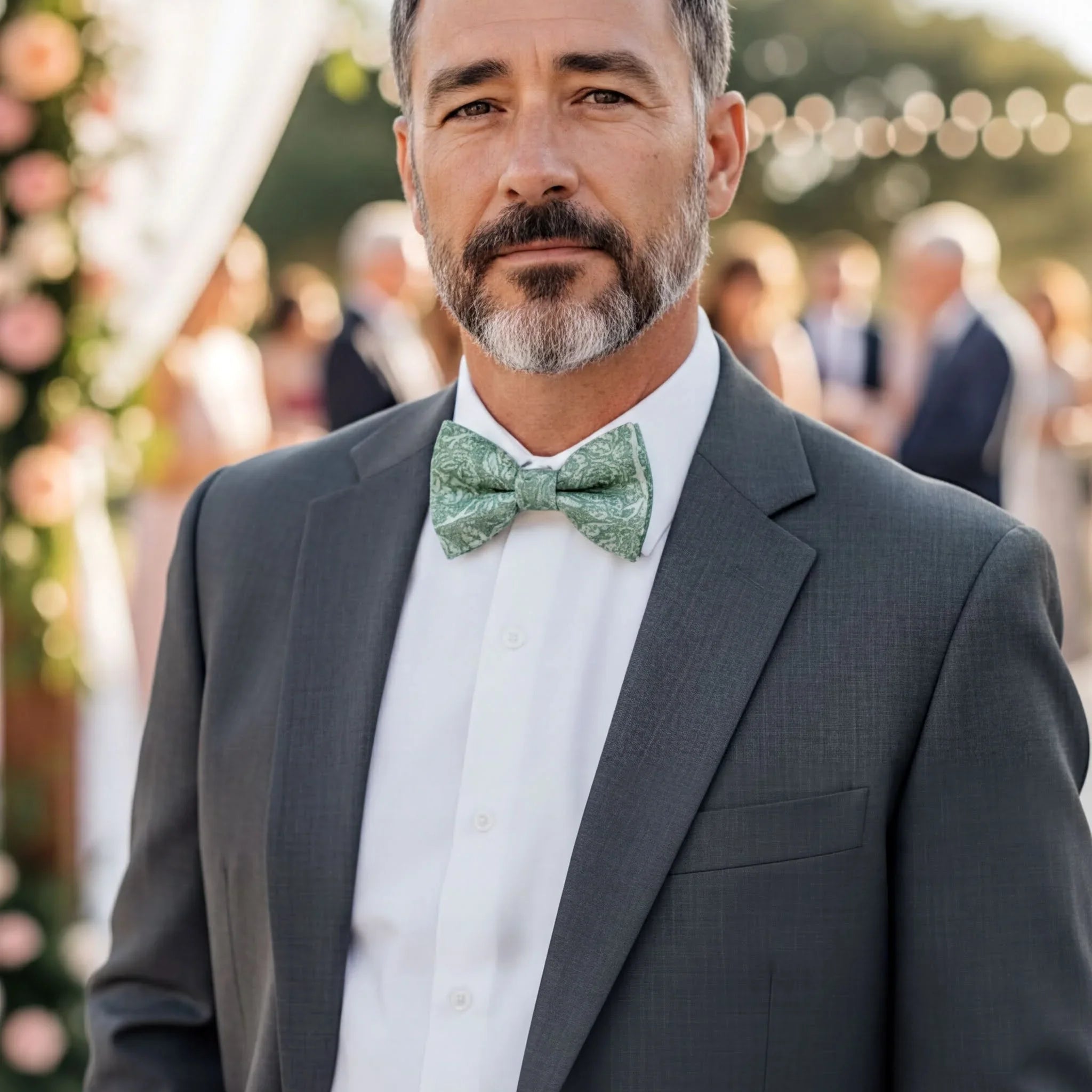 Sage bow tie worn by a man in a suit.