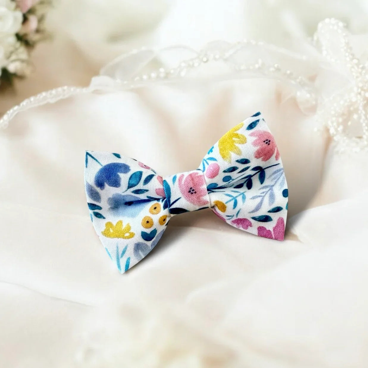 Size chart for pre-tied bow ties from The Bold Bow Tie detailing measurements across three sizes. Small is 3.5 inches wide and recommended for ages 6 months to 5 years. Medium is 4 inches wide and recommended for ages 6 to 12 years. Large is 4.5 inches wide and recommended for ages 13 years and up. Visual icons illustrate the relative sizes with horizontal arrows showing that width is measured from wingtip to wingtip. Bottom text notes that all bow ties are pre-tied and ready to add to your outfit.