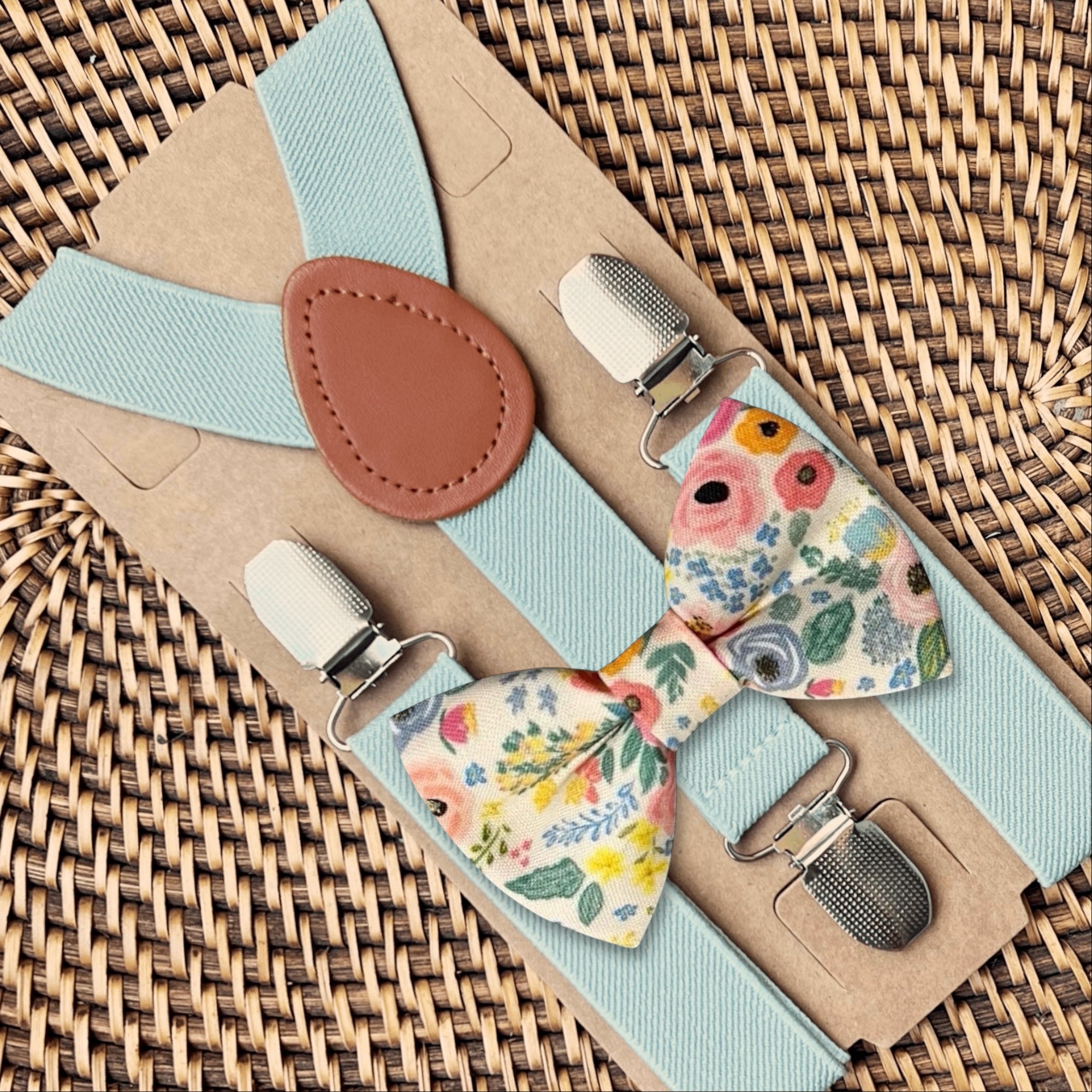 Floral bow tie and suspenders set on a woven surface