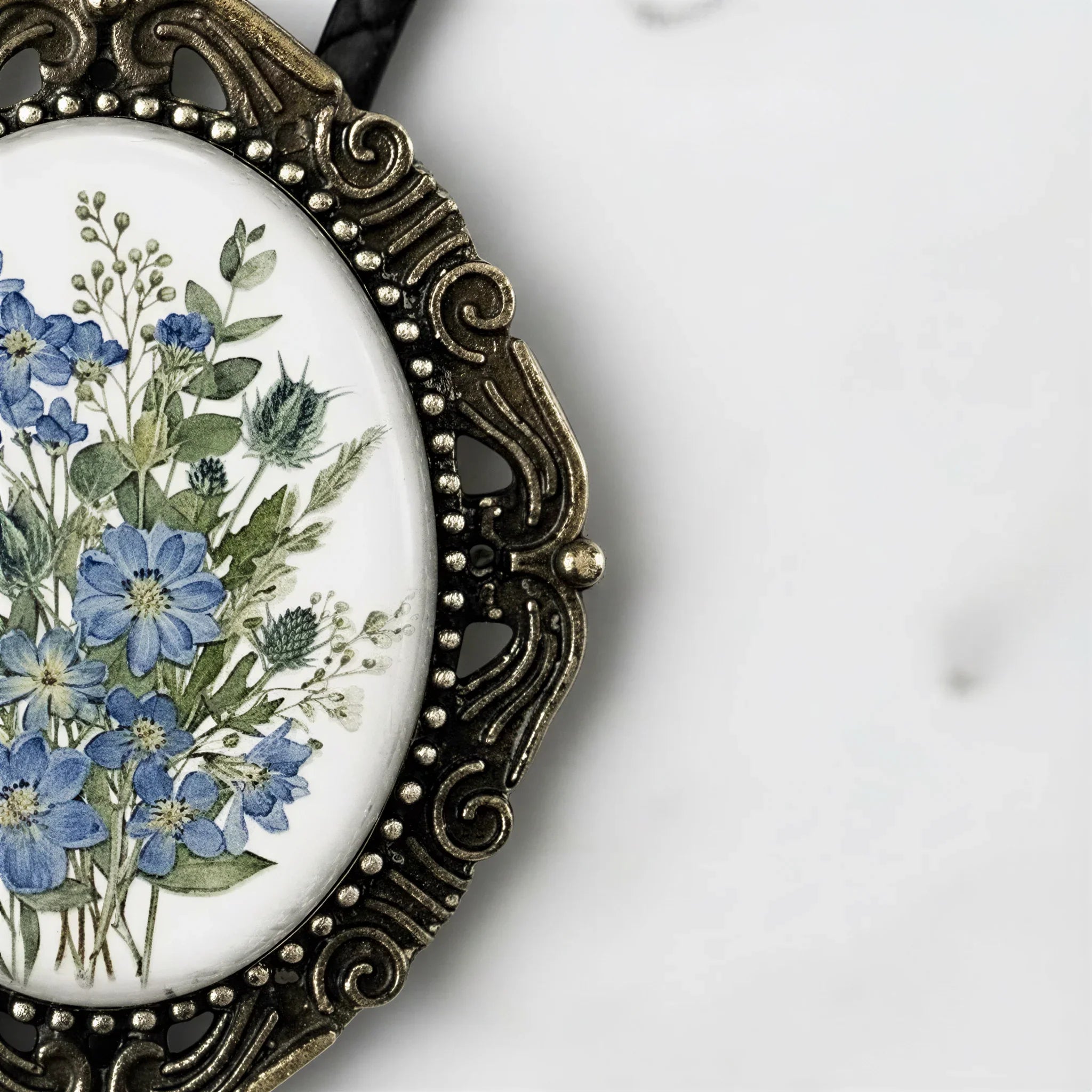 A decorative oval-shaped frame with a floral design on the inside, placed on a white surface.