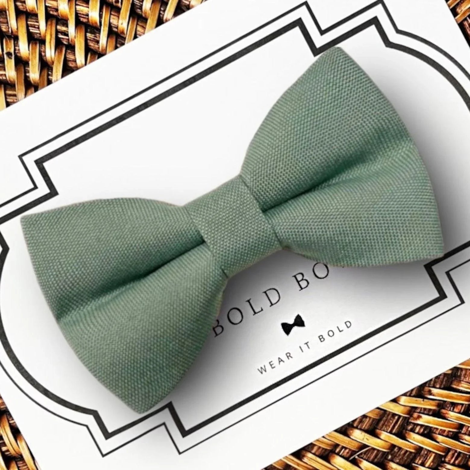 Product graphic showcasing the back of a pre-tied bow tie in a red and black buffalo plaid pattern, resting on a rustic wood surface. Two black elastic loops are attached to the center knot to slide onto a pet collar. Overlay text reads: Back of Bow Tie (may not be actual bow tie in listing).