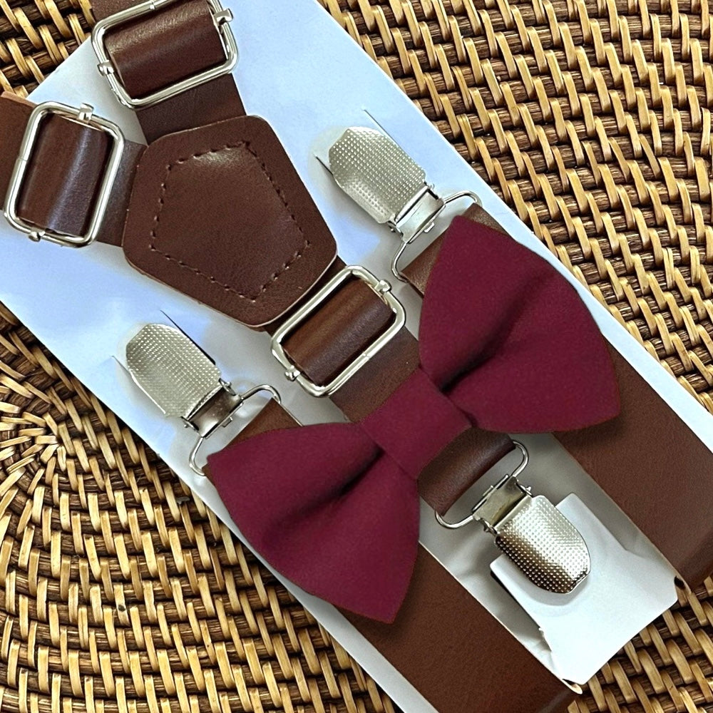 Brown suspenders with Cabernet bow tie on a woven surface