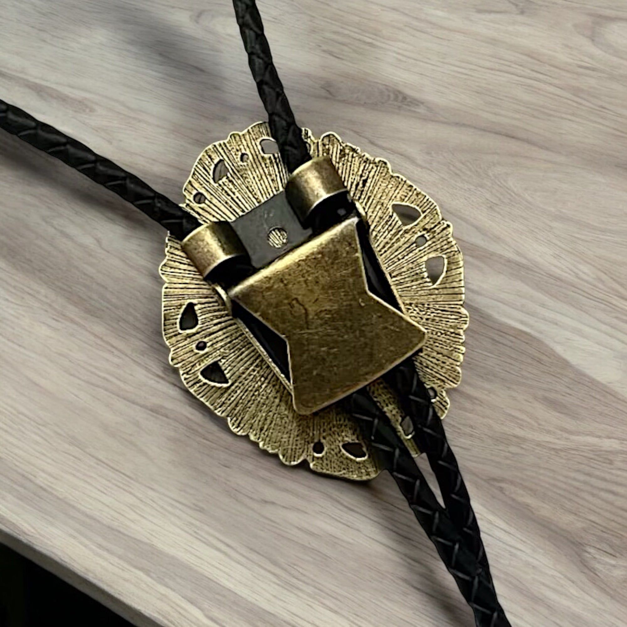 Brass bolo tie on a wooden surface