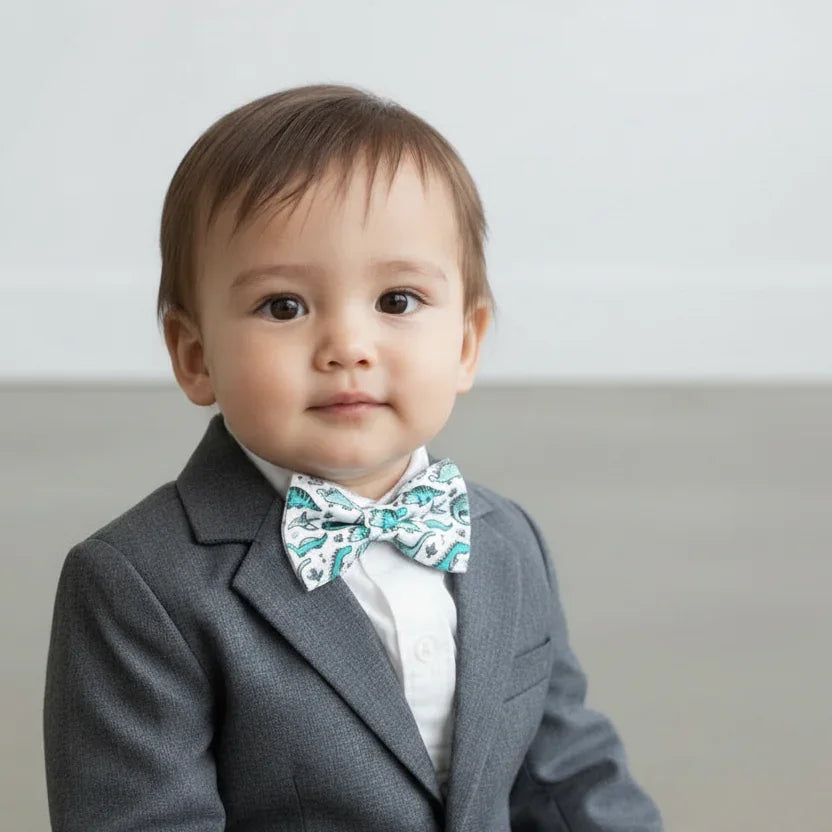Toddler bow tie in dinosaur print worn by a ring bearer in a wedding.