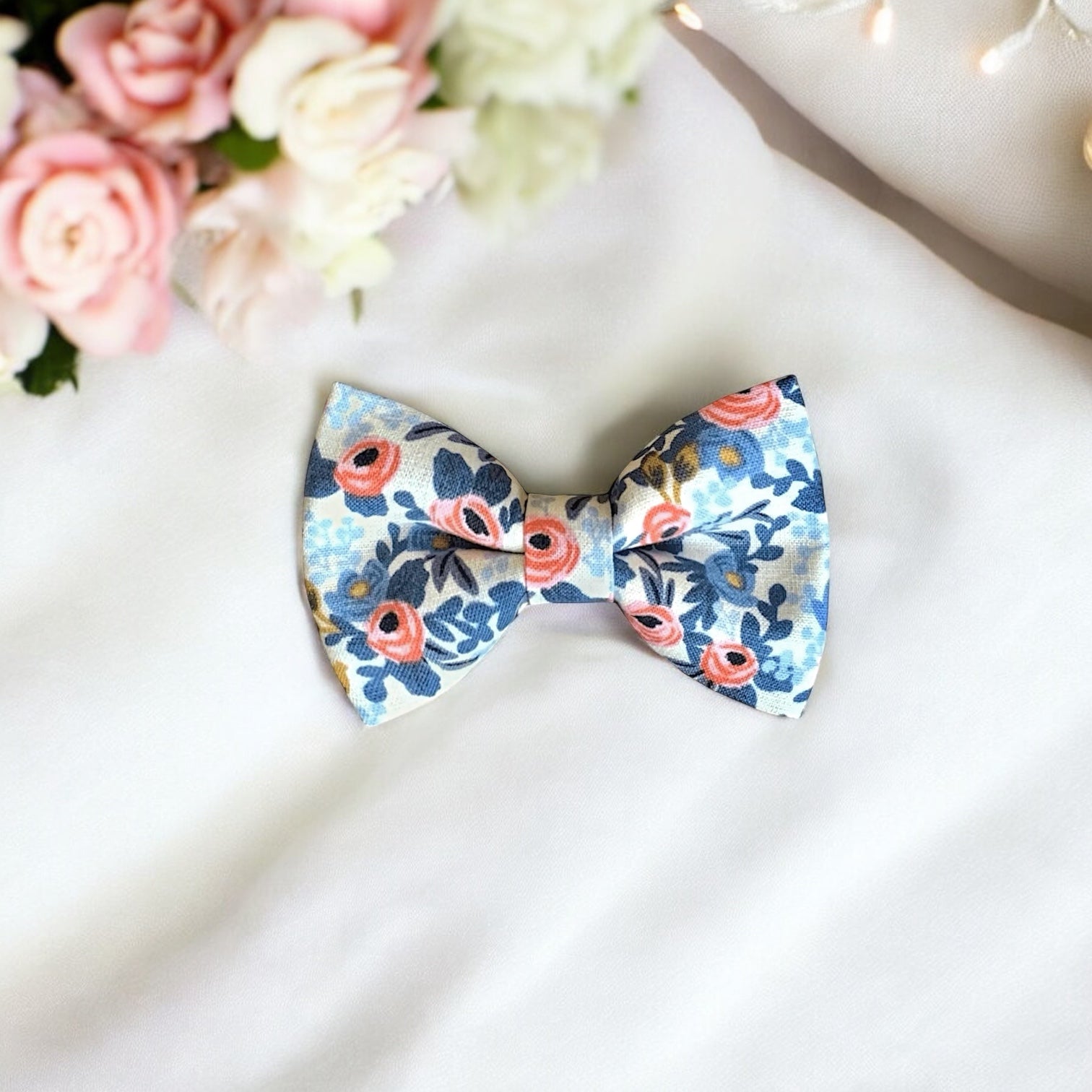 Floral Bow Tie- White, Blue, Pink Rifle Paper Co Garden Party Fabric for wedding, ring bearer outfit or groomsmen surrounded by flowers on a white tablecloth.