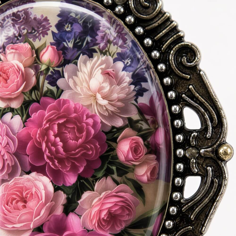 a close-up of a decorative oval frame with a floral design, containing a variety of pink and purple flowers.