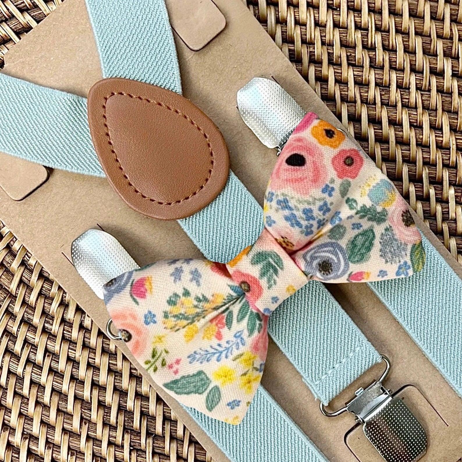 Floral bow tie for garden wedding and suspenders on a woven surface