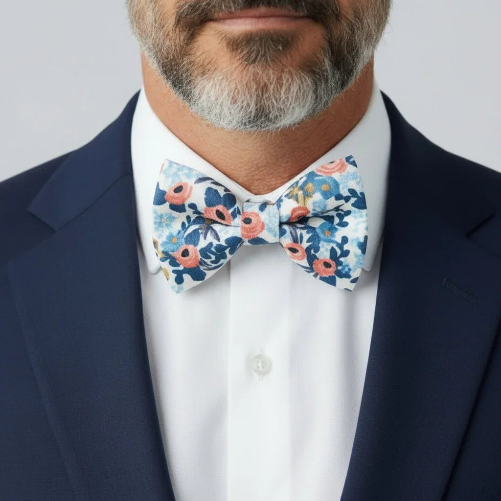 Size chart for pre-tied bow ties from The Bold Bow Tie detailing measurements across three sizes. Small is 3.5 inches wide and recommended for ages 6 months to 5 years. Medium is 4 inches wide and recommended for ages 6 to 12 years. Large is 4.5 inches wide and recommended for ages 13 years and up. Visual icons illustrate the relative sizes with horizontal arrows showing that width is measured from wingtip to wingtip. Bottom text notes that all bow ties are pre-tied and ready to add to your outfit.