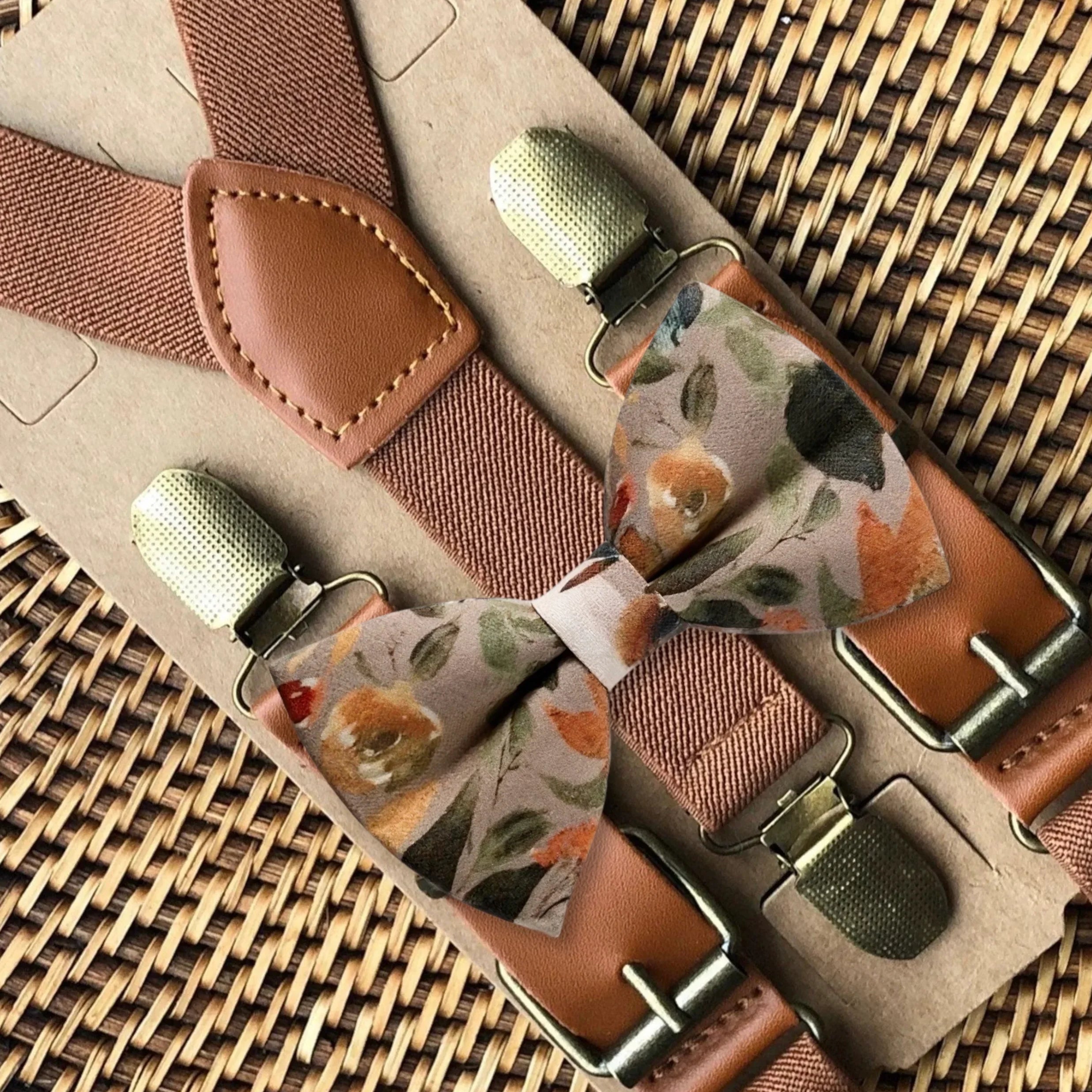 Taupe floral bow tie with terracotta suspenders and leather patch details on a textured backdrop.