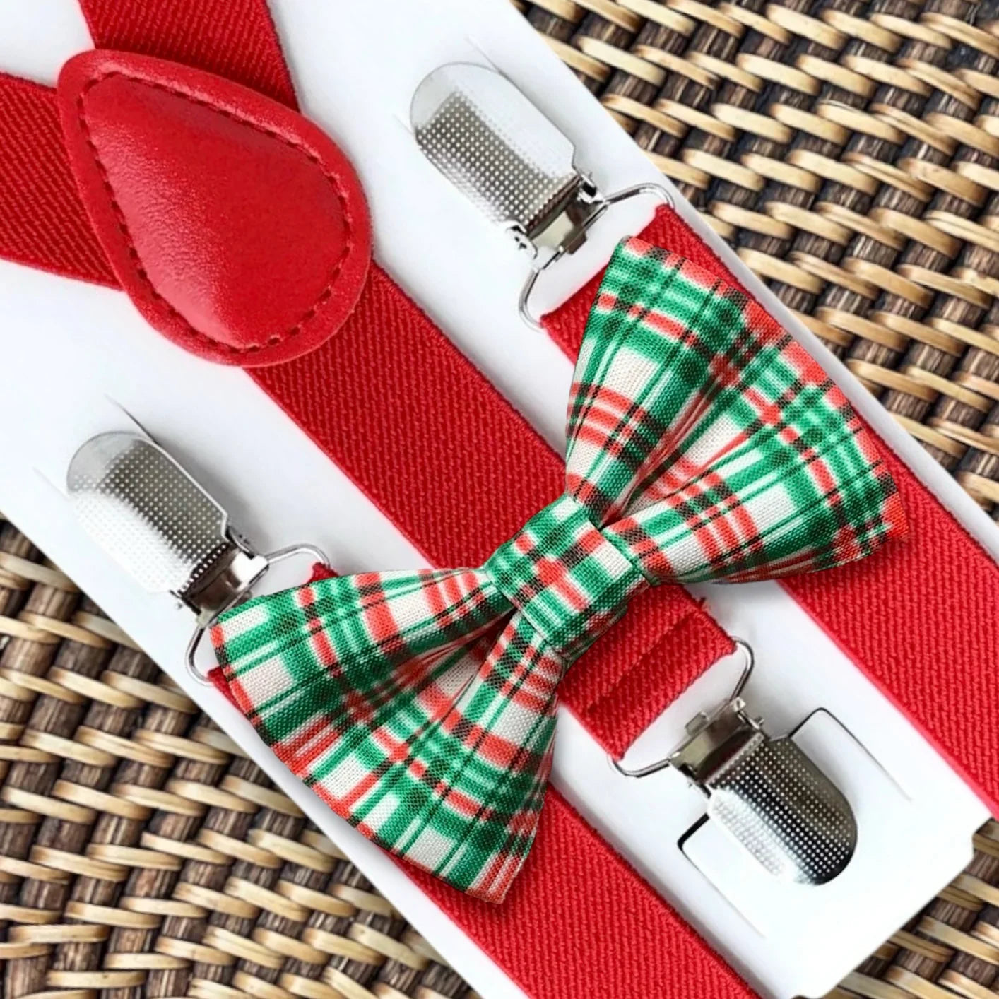 Red bow tie with red suspenders and metal clip clasps on a white display card