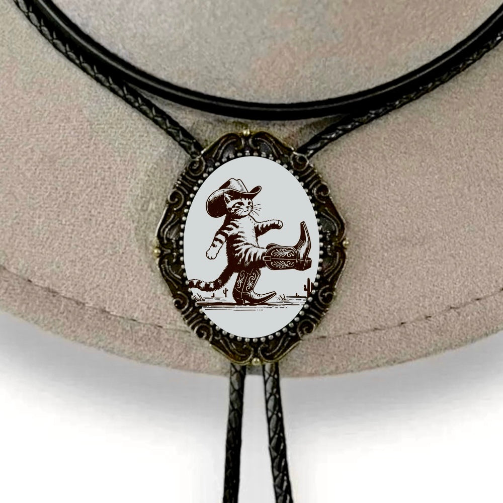 Bolo Tie with Cowboy Kitten on bronze bezel displayed on a gray cowboy hat