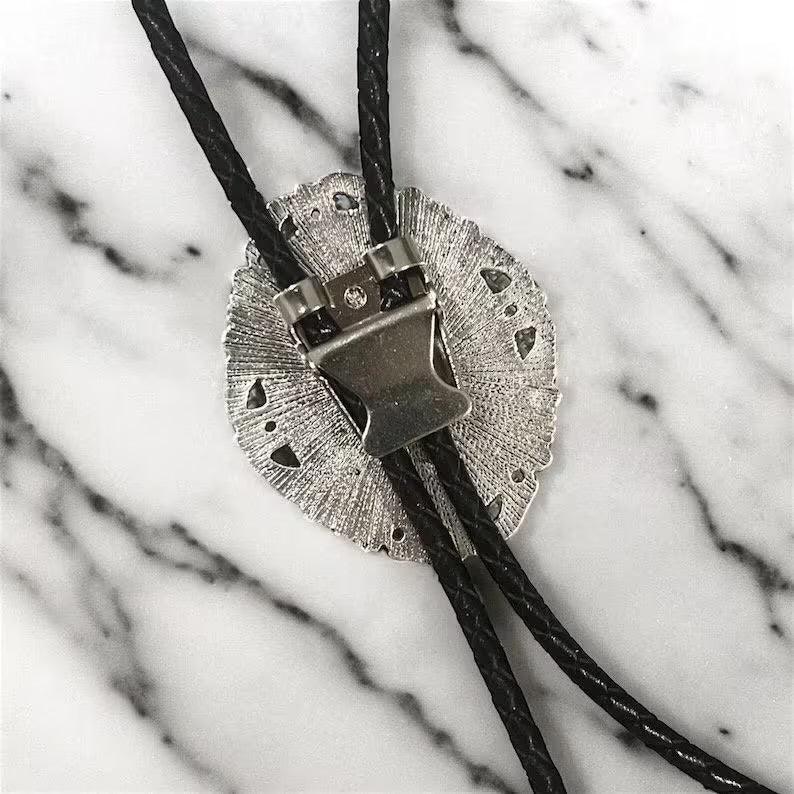 Closeup of back of silver and black bolo tie
