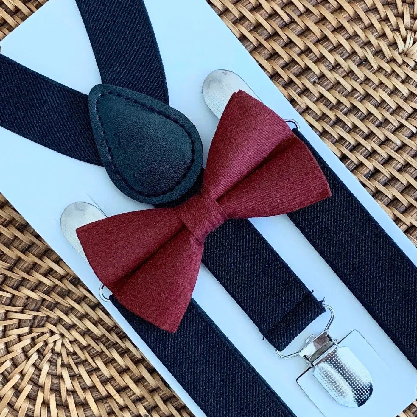 Burgundy bow tie and black suspenders.