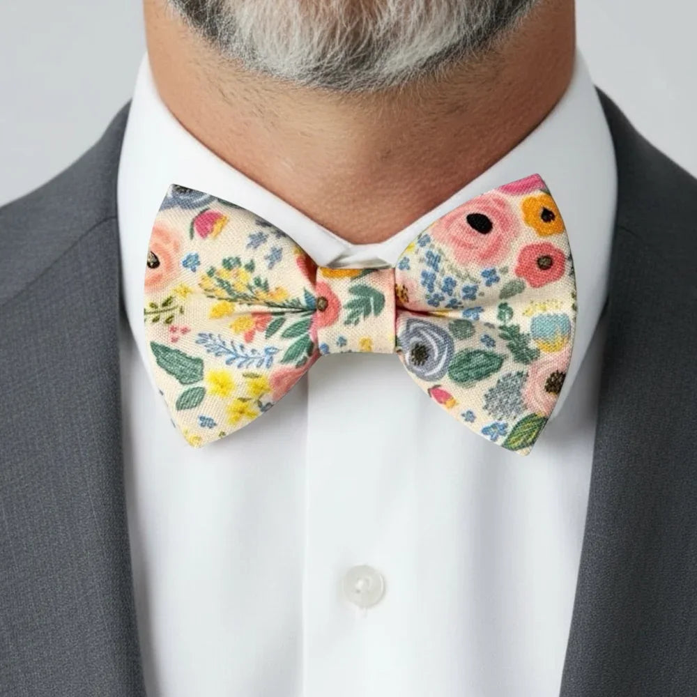 Floral bow tie for men worn by a man at a wedding in a suit.