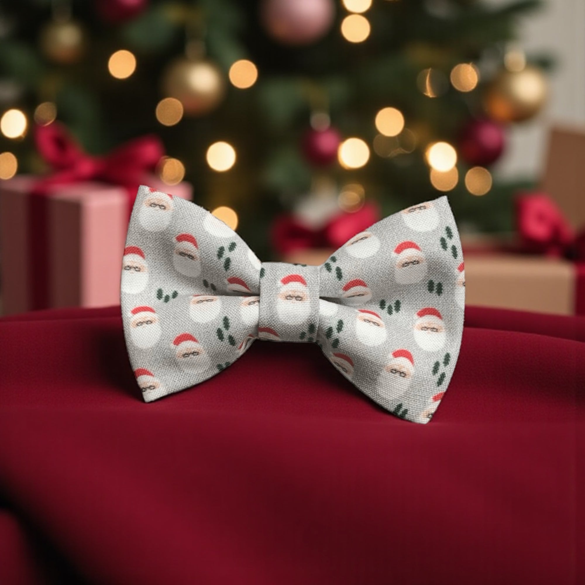 Christmas-themed bow tie with Santa Claus pattern on a red surface with blurred festive background