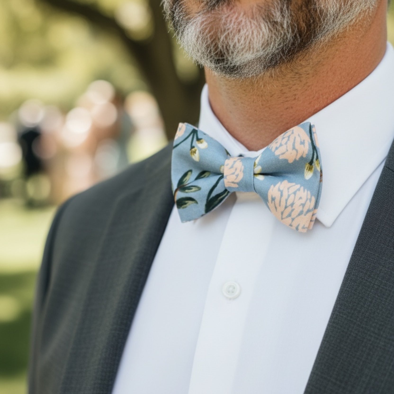Dusty blue floral bow tie worn by a groomsman in a wedding.