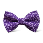a purple bow tie with white flowers on it