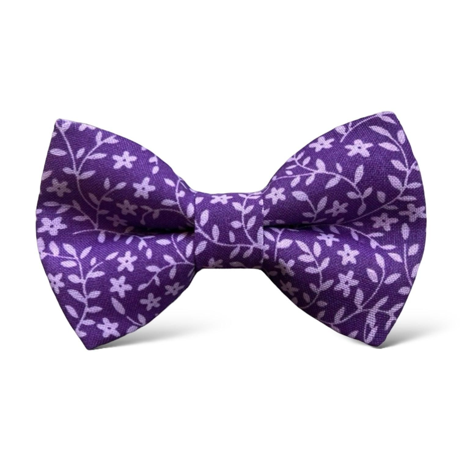 a purple bow tie with white flowers on it