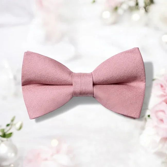 Size chart for pre-tied bow ties from The Bold Bow Tie detailing measurements across three sizes. Small is 3.5 inches wide and recommended for ages 6 months to 5 years. Medium is 4 inches wide and recommended for ages 6 to 12 years. Large is 4.5 inches wide and recommended for ages 13 years and up. Visual icons illustrate the relative sizes with horizontal arrows showing that width is measured from wingtip to wingtip. Bottom text notes that all bow ties are pre-tied and ready to add to your outfit.
