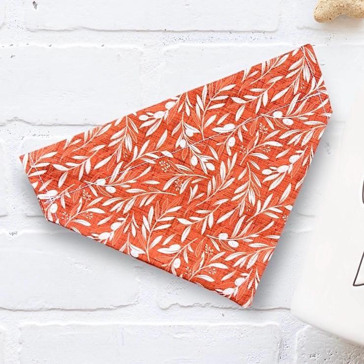 Orange fall themed dog bandana with white leaf pattern on white background