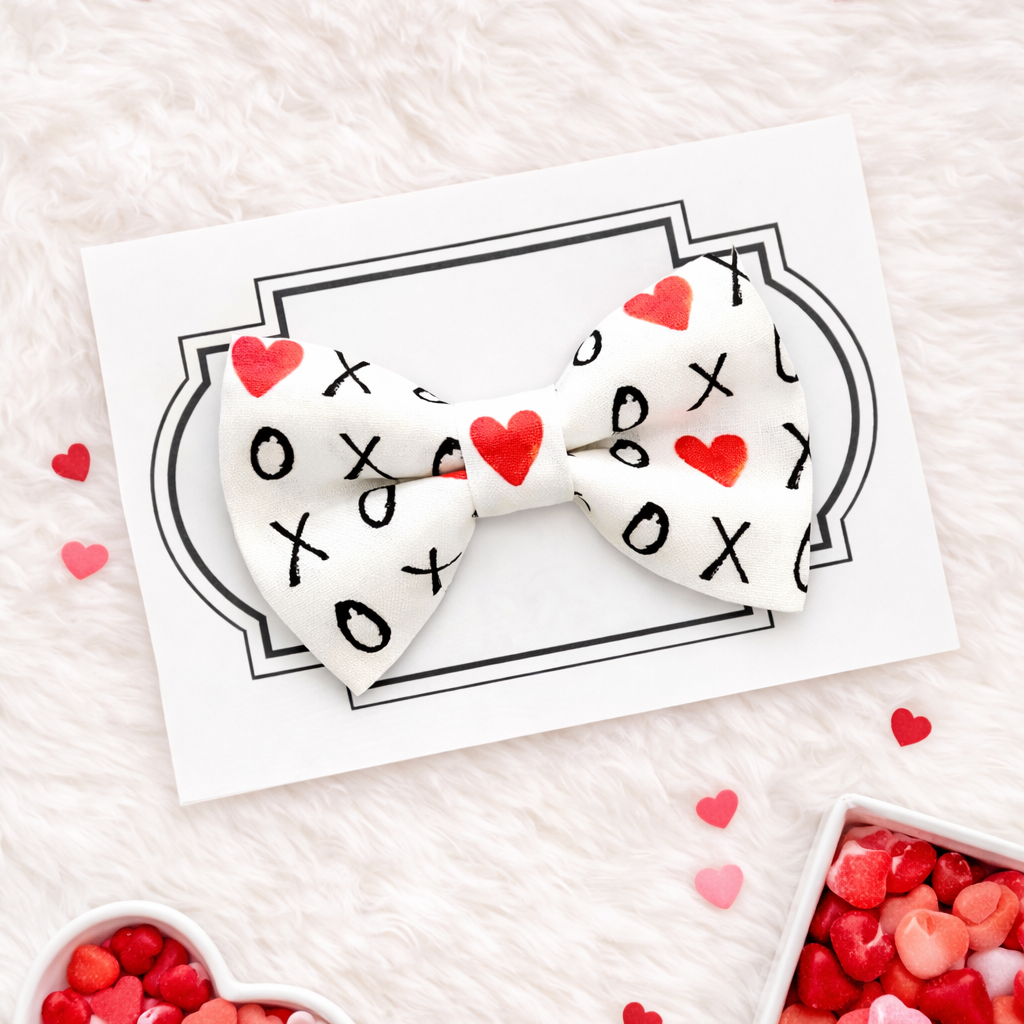 White dog bow tie with hearts and Xoxo for Valentines Day.
