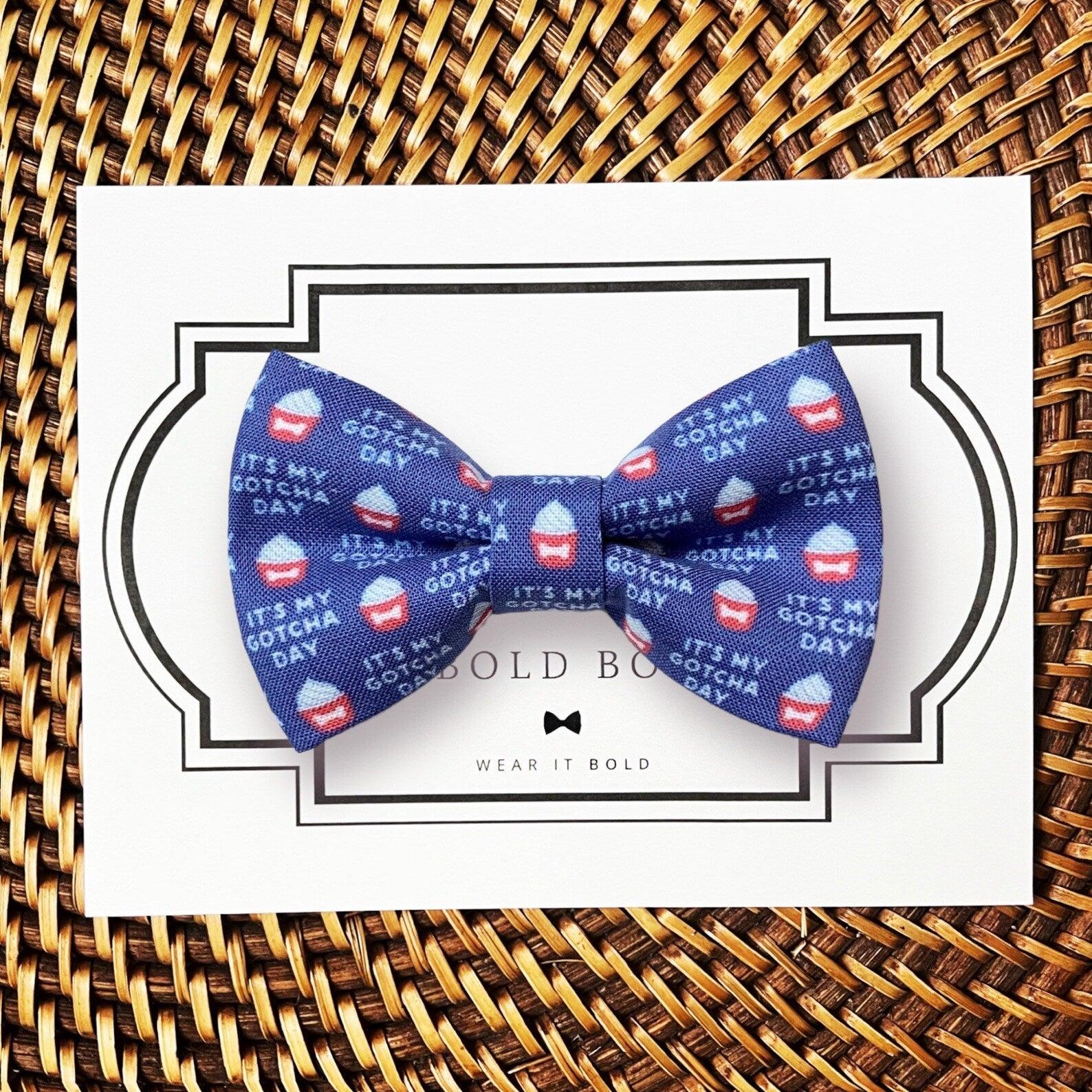 a blue dog bow tie with red, white and blue cupcakes on it that says “It’s my gotcha day”