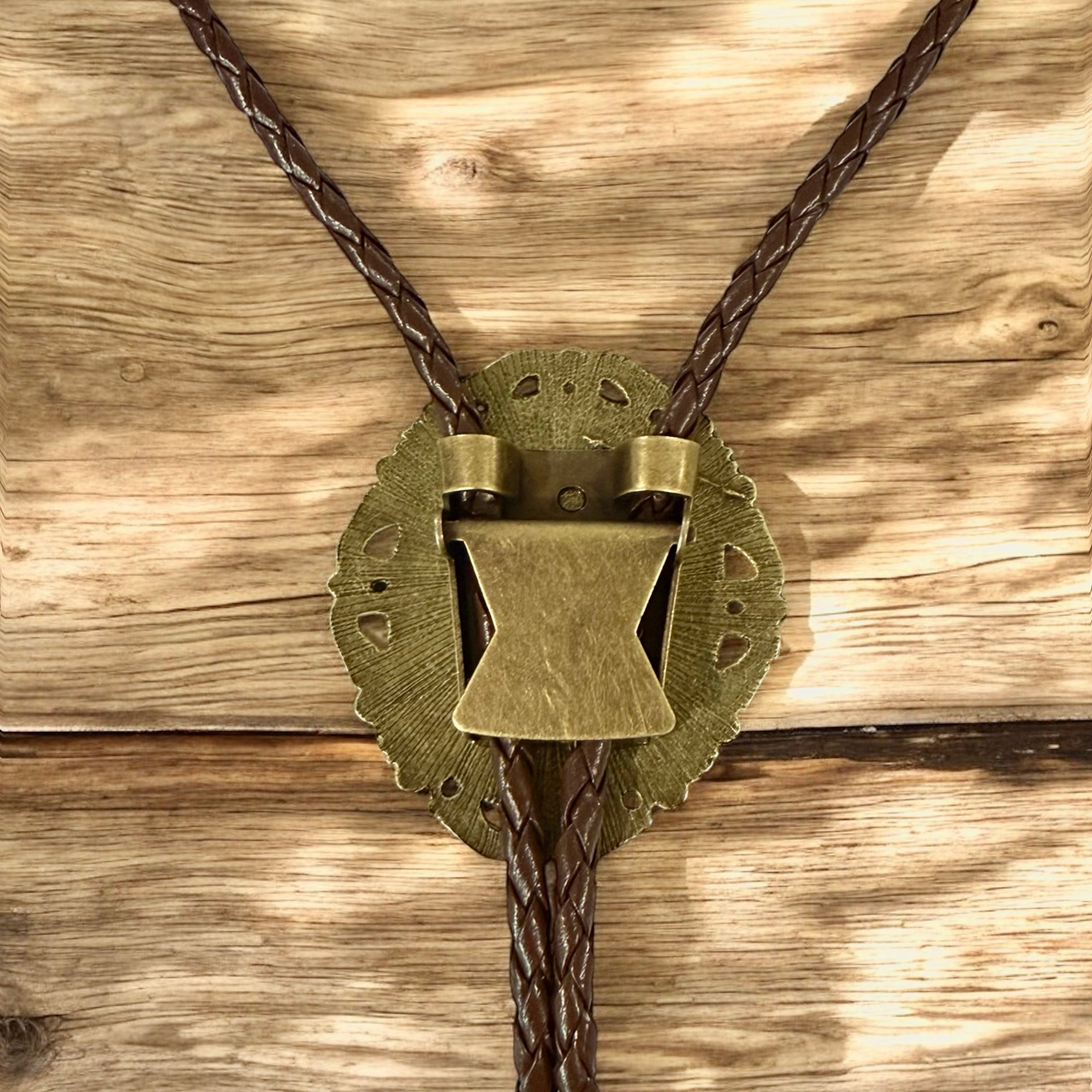 Bronze bolo tie on a wooden background