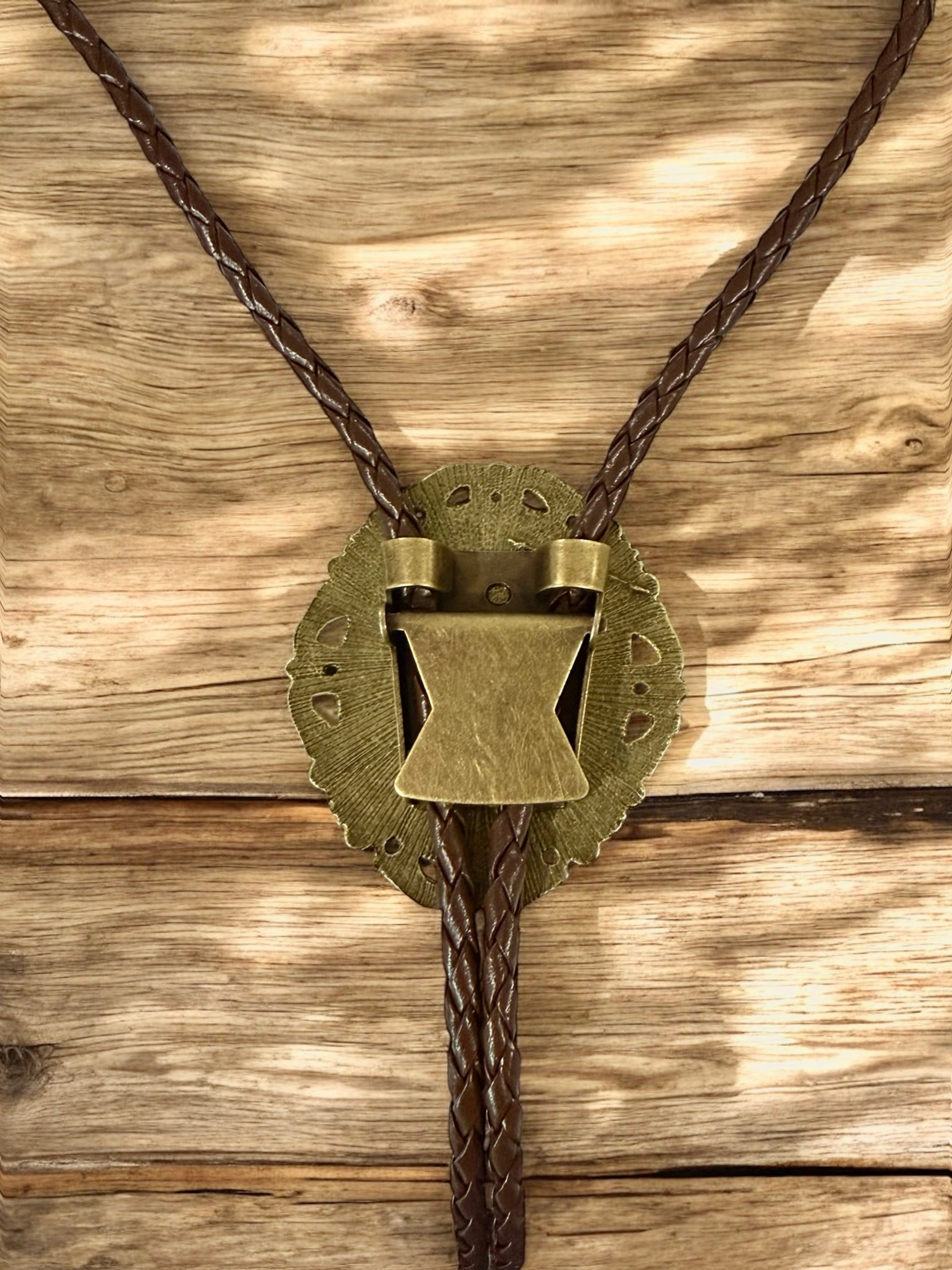 Bronze bolo tie on a wooden background