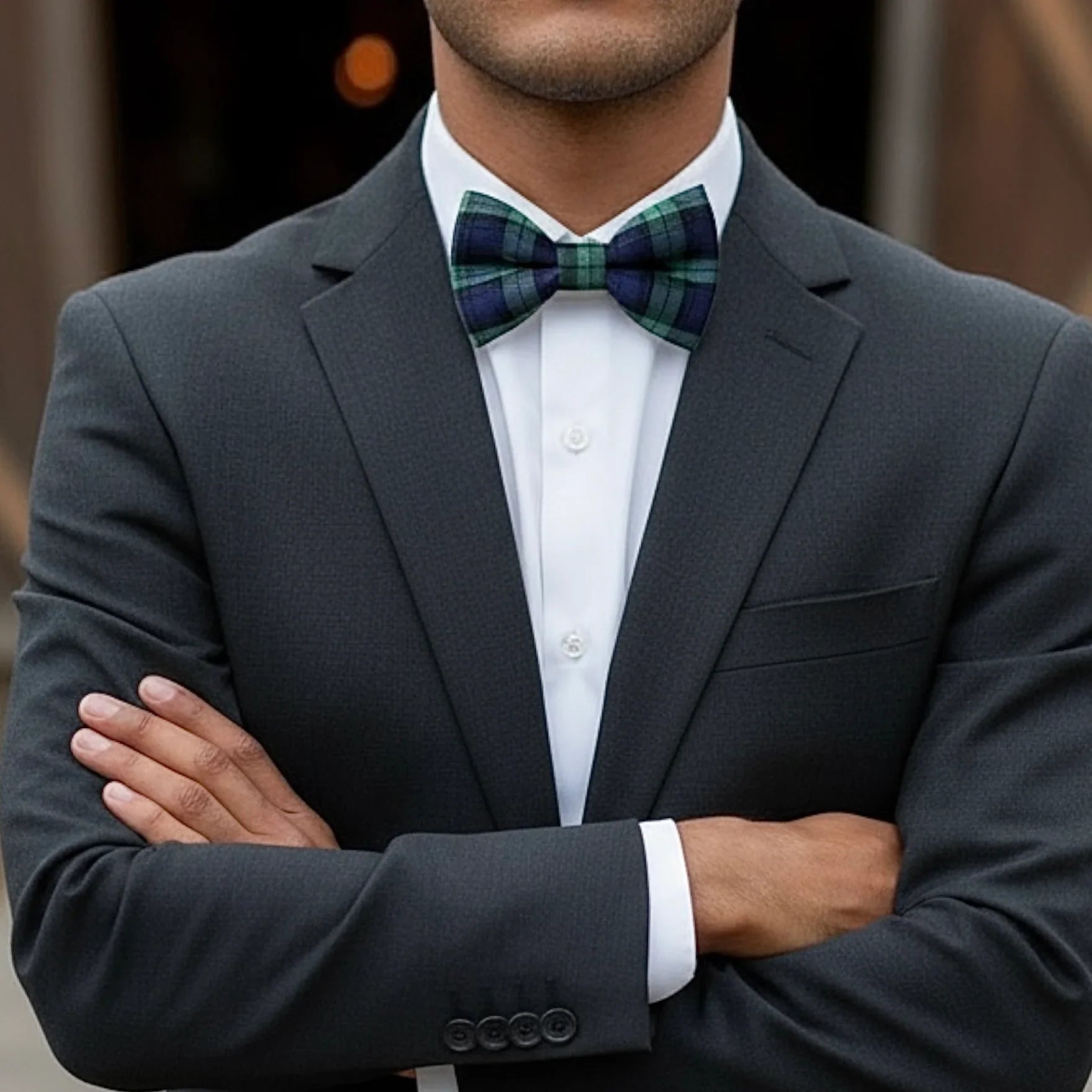 Plaid navy and green bow tie worn by a man in a suit.