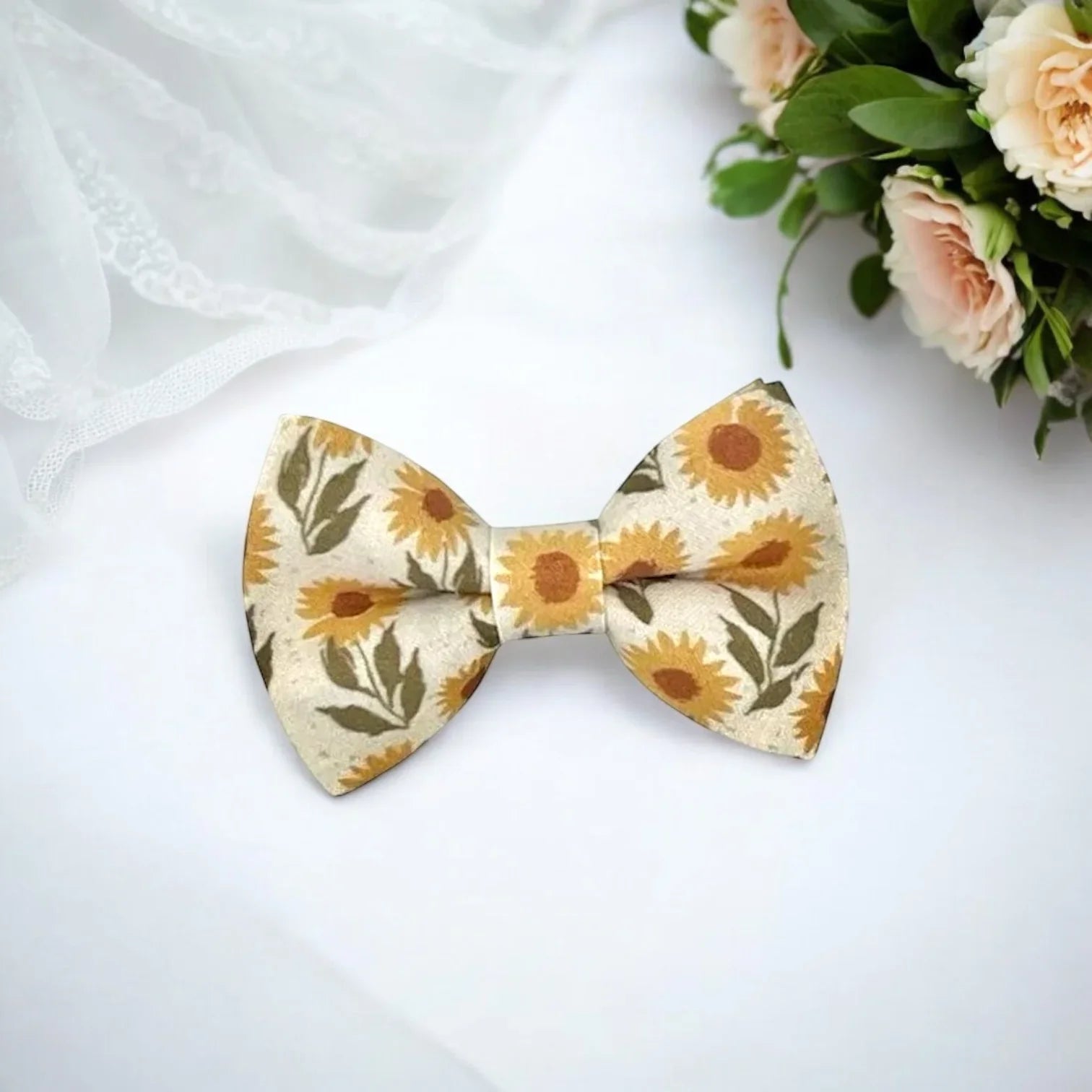 Floral bowtie with sunflowers on a white table with wedding bouquet.