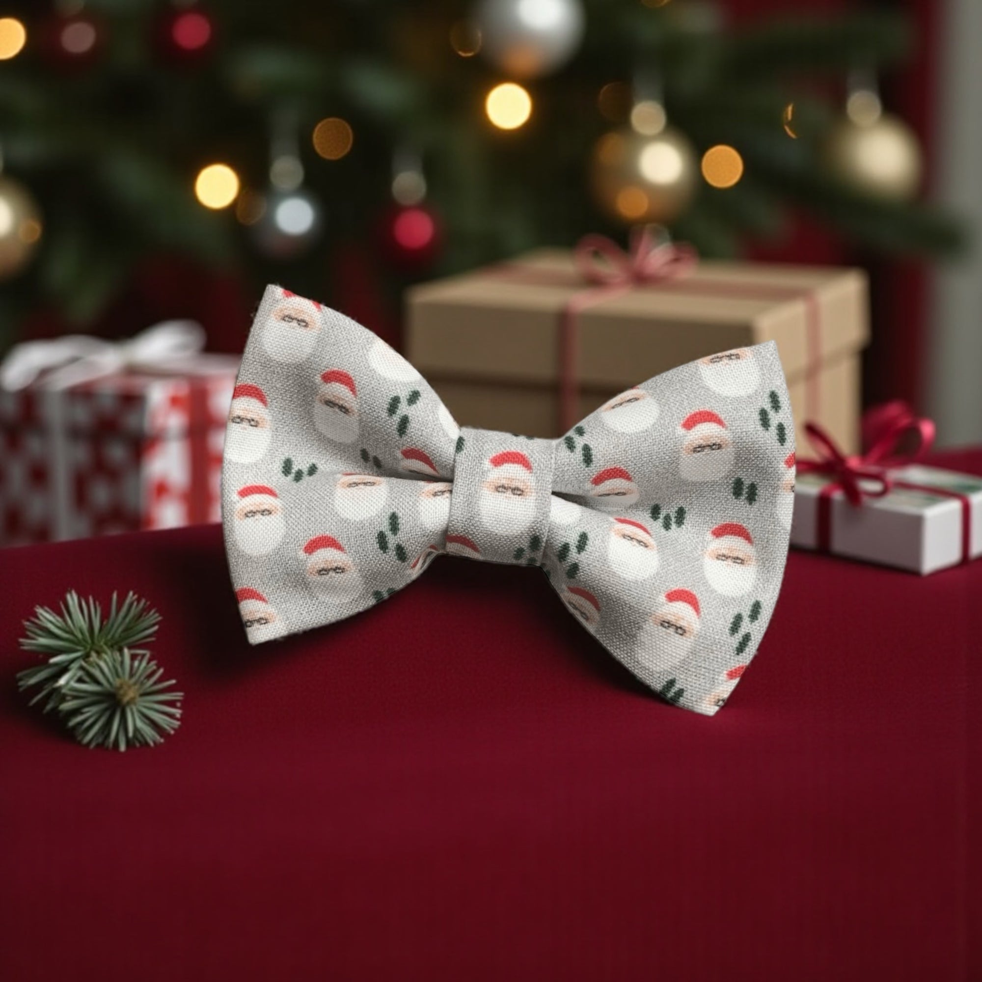 Bow tie with Santa Claus pattern on a red surface with Christmas decorations in the background