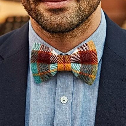 Plaid bow tie in orange blue and white worn by a man in a suit.