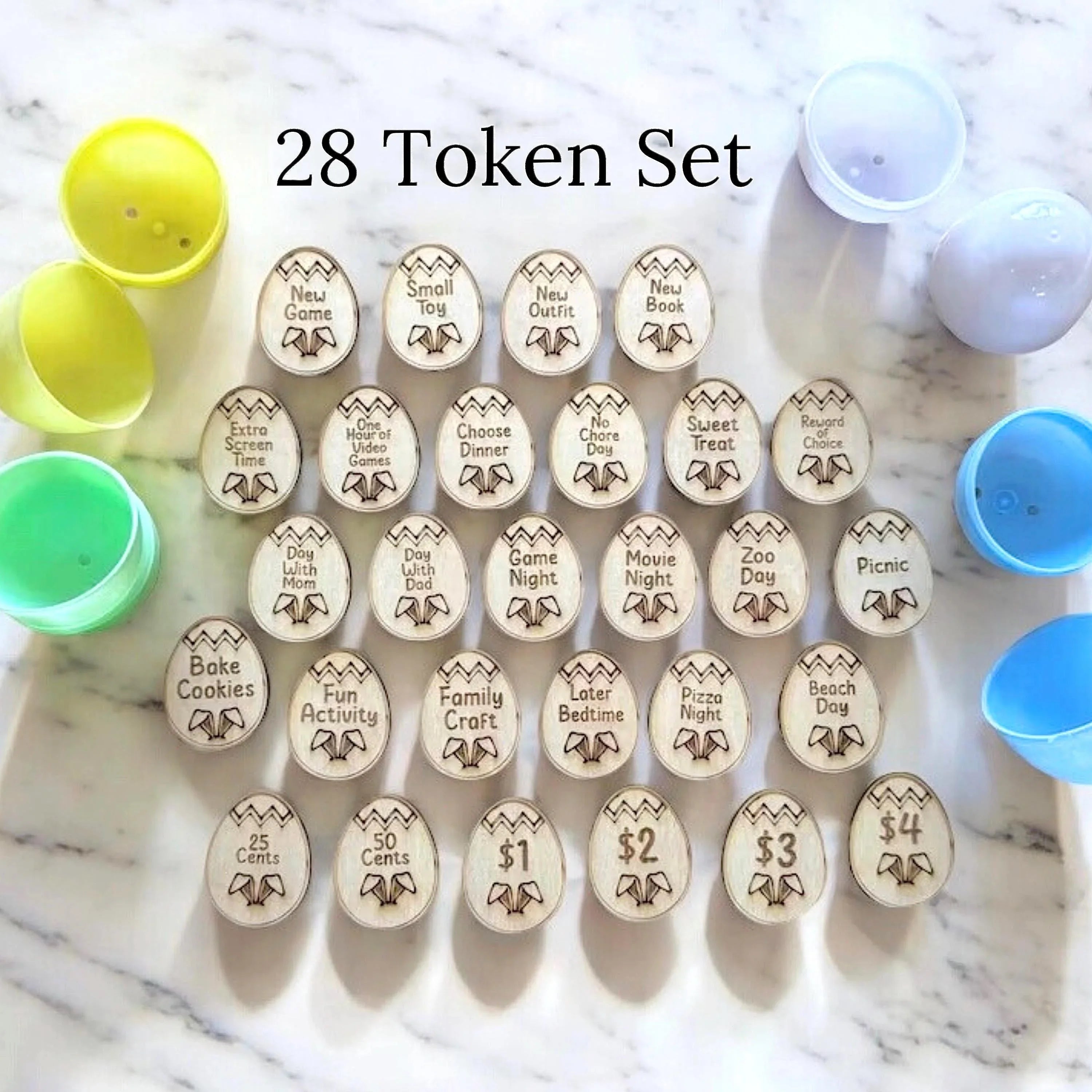 Row of wooden activity tokens with prompts like New Game Night arranged on a marble surface