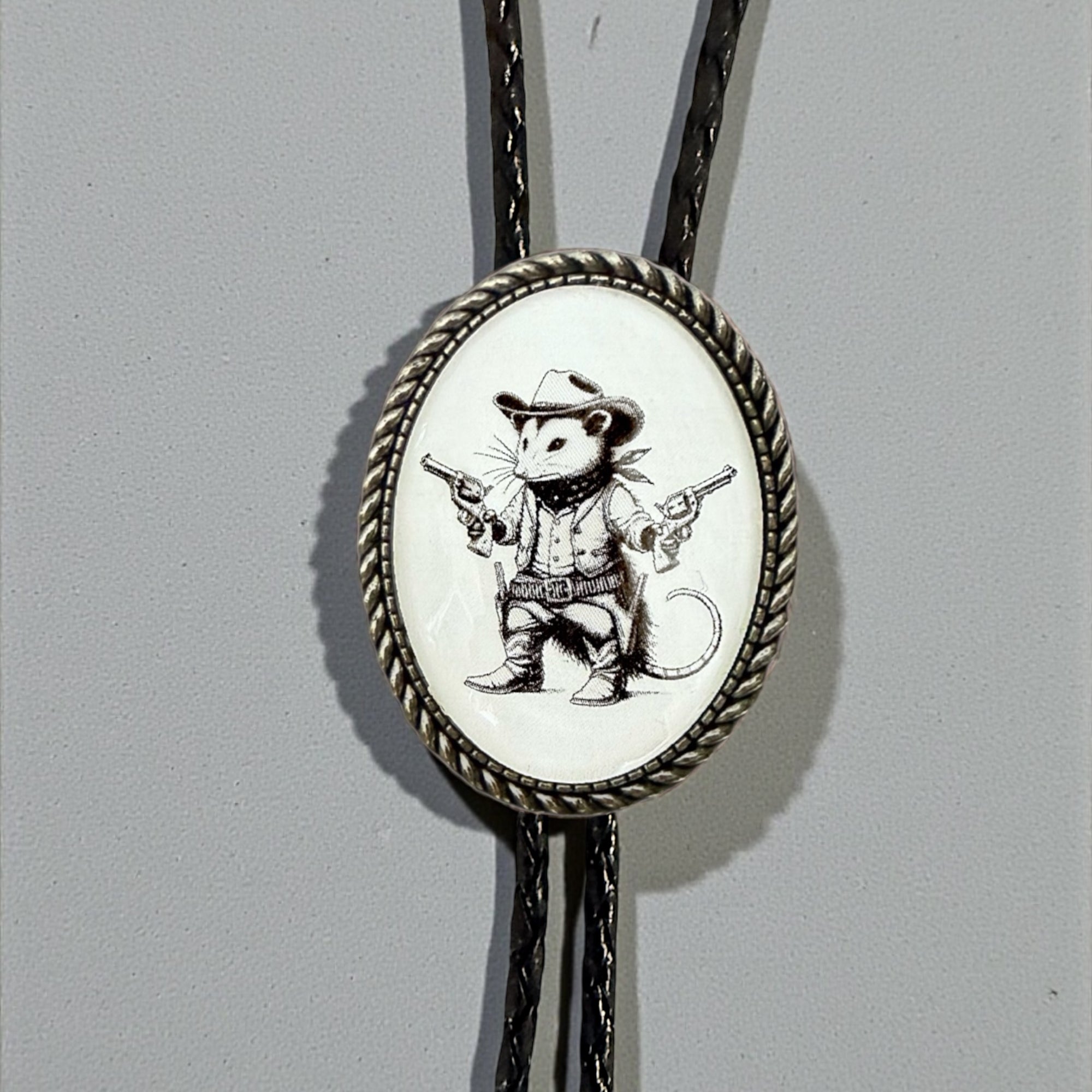 Opossum Bolo Tie for Men and Women — Handmade Country Western Weddings On a gray background.