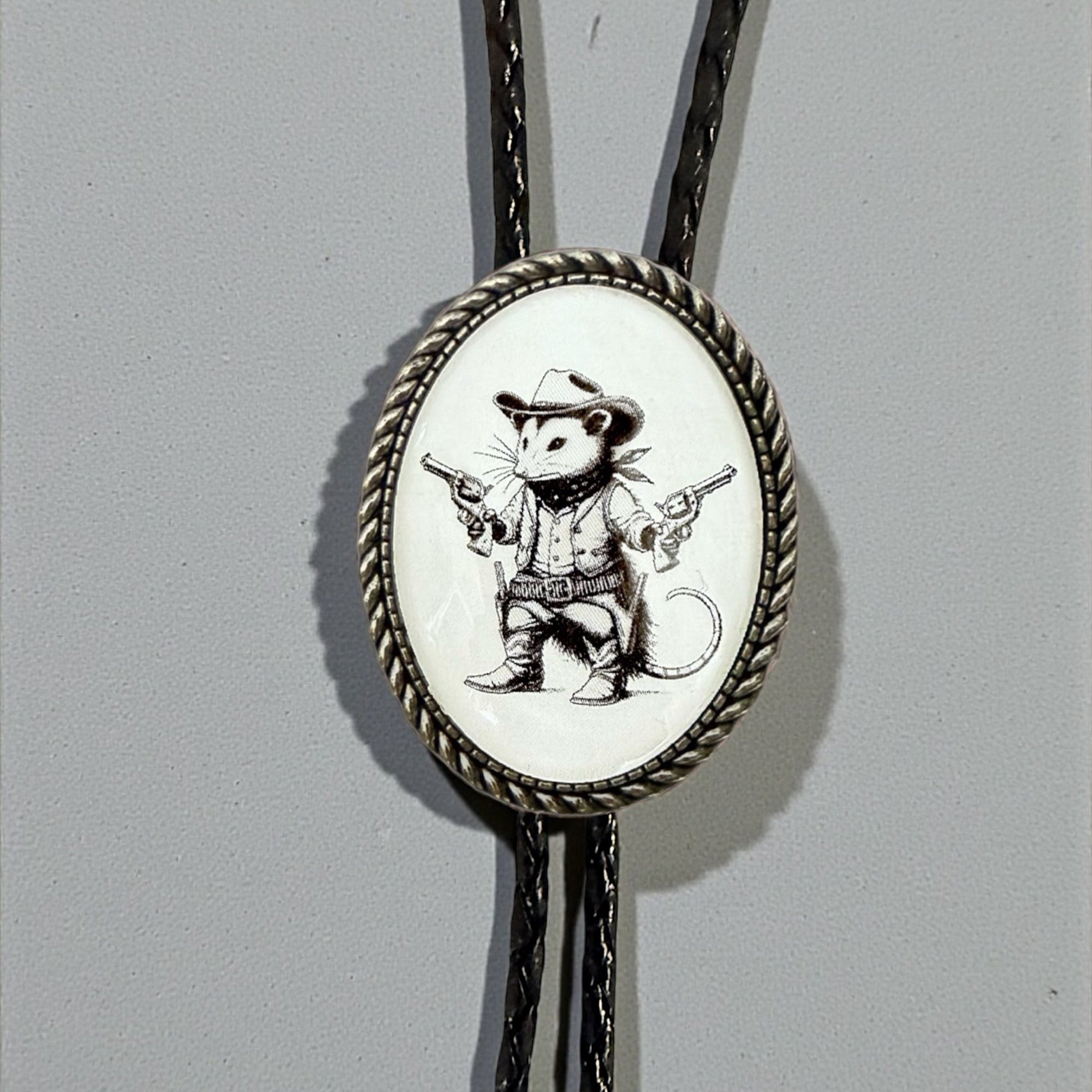 Opossum Bolo Tie for Men and Women — Handmade Country Western Weddings On a gray background.