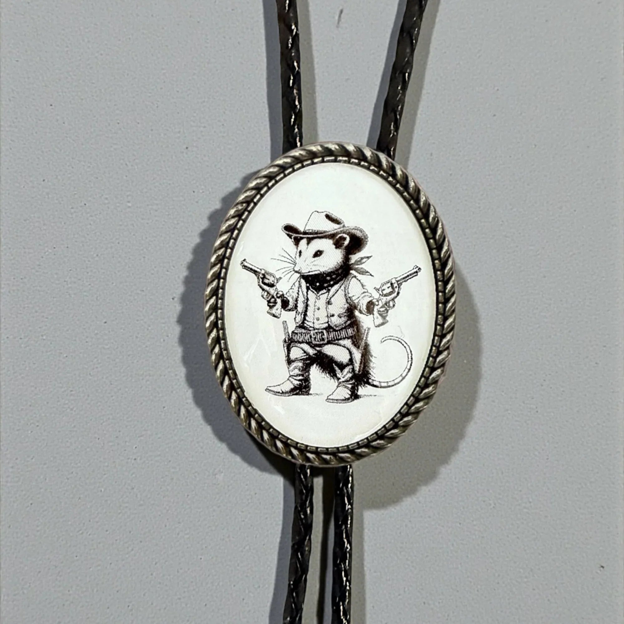 Opossum Bolo Tie for Men and Women — Handmade Country Western Weddings On a gray background.