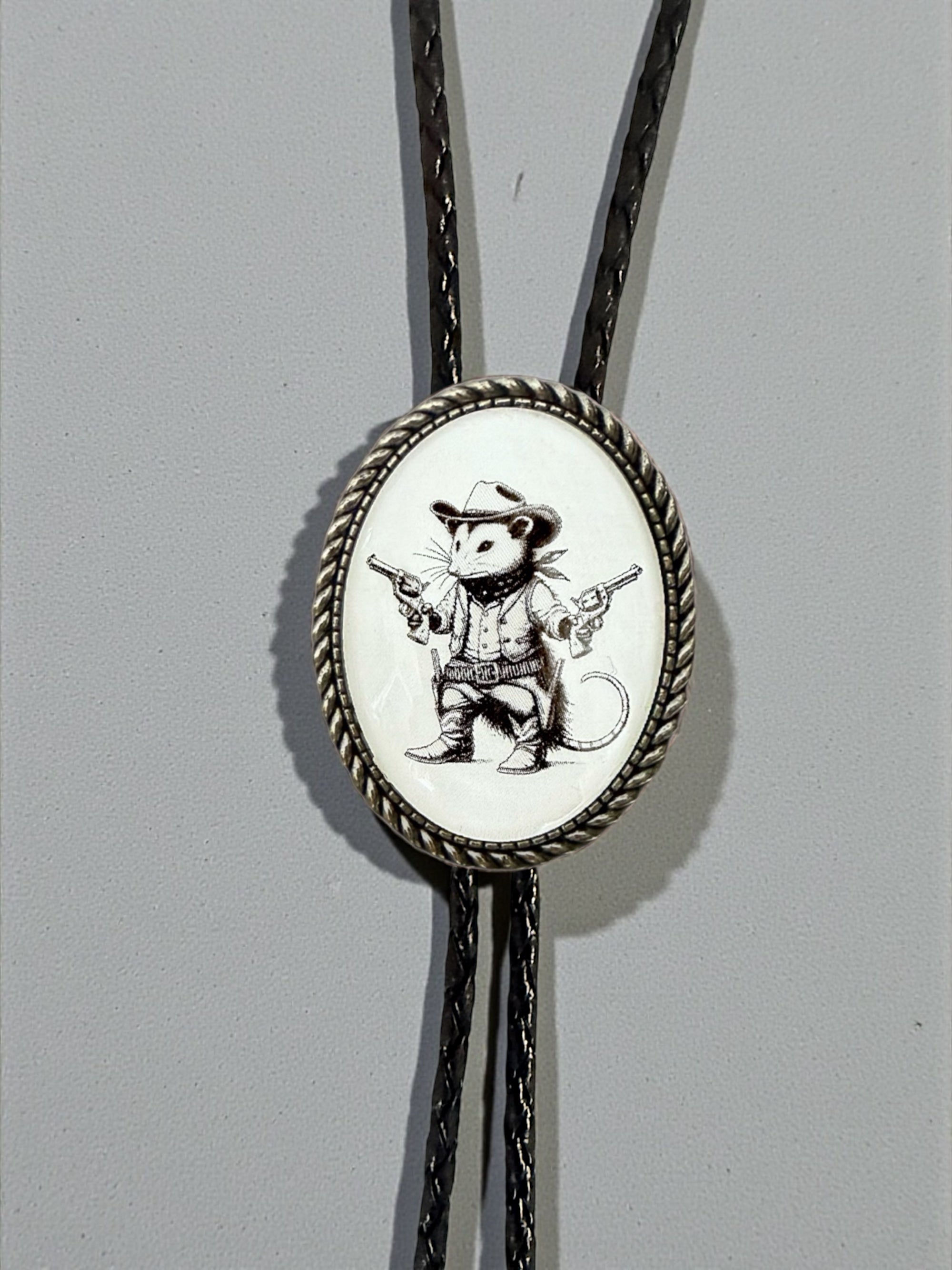 Opossum Bolo Tie for Men and Women — Handmade Country Western Weddings On a gray background.