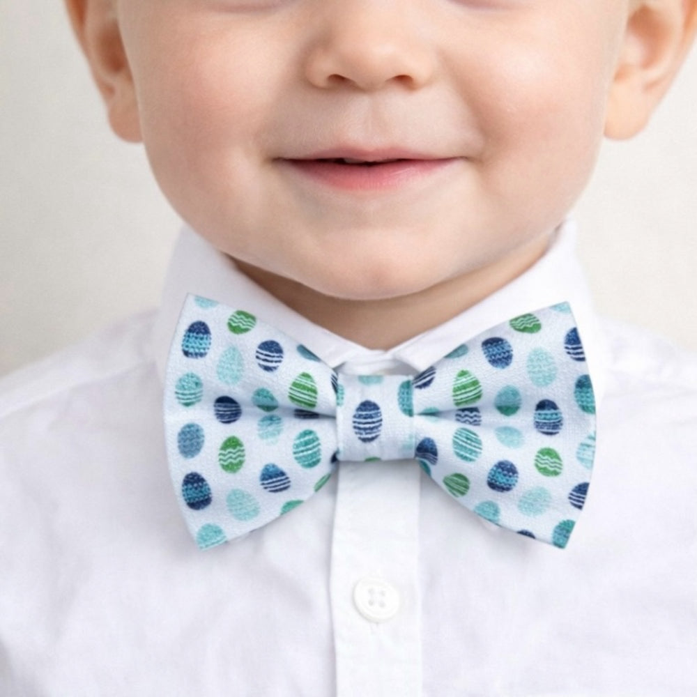 Size chart for pre-tied bow ties from The Bold Bow Tie detailing measurements across three sizes. Small is 3.5 inches wide and recommended for ages 6 months to 5 years. Medium is 4 inches wide and recommended for ages 6 to 12 years. Large is 4.5 inches wide and recommended for ages 13 years and up. Visual icons illustrate the relative sizes with horizontal arrows showing that width is measured from wingtip to wingtip. Bottom text notes that all bow ties are pre-tied and ready to add to your outfit.